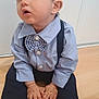 toddler, child, boy, barefoot, blue_shirt, bow_tie, suspenders, hat, cap, floor, wooden_floor, sitting, indoors, cute, curious, hands, feet, portrait, clothing, face