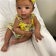 E Zaylee joined the competition — help win amazing prizes! baby, bed, big_eyes, blanket, bow, child, curly_hair, cute, fabric, hands, headband, indoor, infant, portrait, sitting, skin, smile, toes, wall, yellow_dress