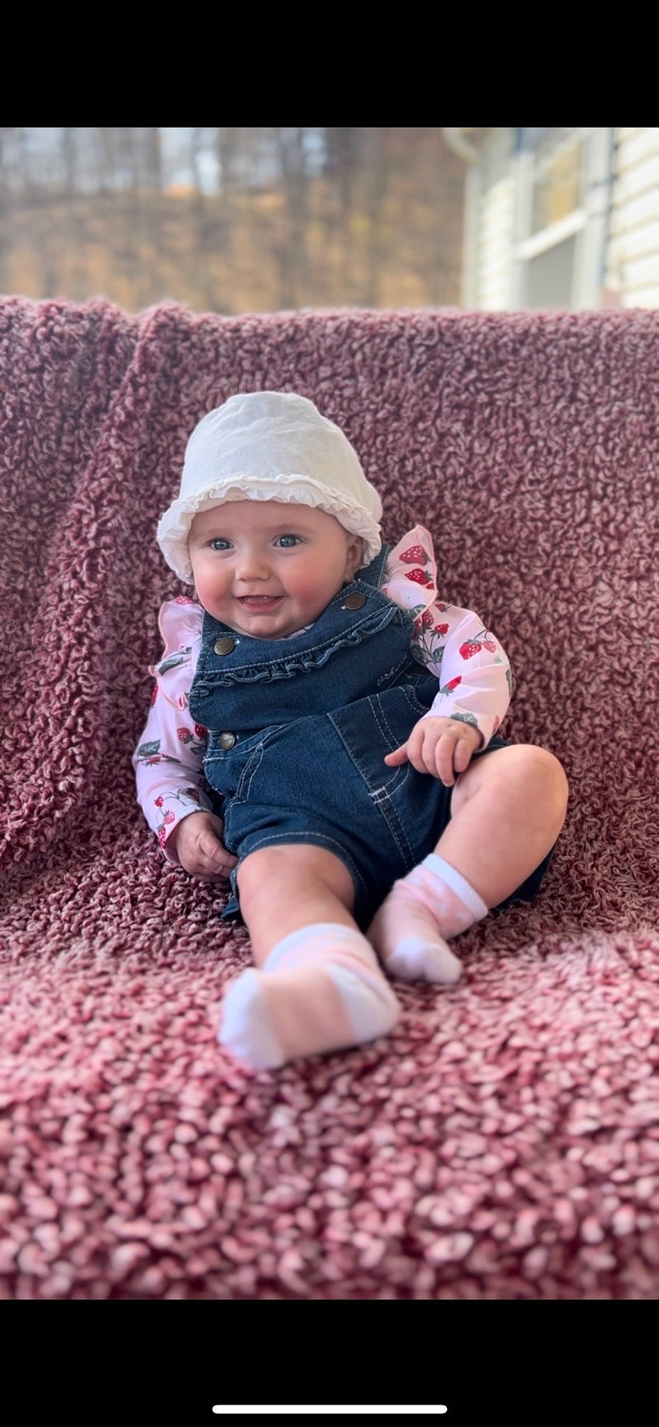 Clara is registered to the contest to win money with this photo: baby, baby_toddler_clothing, cap, cheek, comfort, eye, face, flooring, foot, grass, happy, head, headwear, human_body, knit_cap, person, sitting, skin, textile, toddler