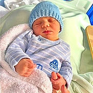 George joined the competition — help win amazing prizes! baby, bed, blanket, blue, cozy, cute, green, hand_holding, hat, hospital_bed, infant, knit_hat, newborn, peaceful, person, resting, sleeping, small_hands, soft_texture, striped_clothing