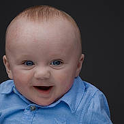 George is registered to the contest to win money with this photo: baby, child, blue_eyes, blue_shirt, smiling, happy, portrait, infant, face, cute, closeup, expression, young, innocent, studio, head, person, skin, clothing, background