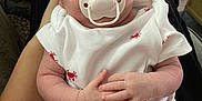 George joined the competition — help win amazing prizes! baby, child, clothing, cute, hands, human, indoor, infant, lap, legs, newborn, onesie, pacifier, peaceful, person, red, resting, skin, sleeping, white