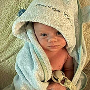George is registered to the contest to win money with this photo: baby, bath_time, blanket, child, cozy, cute, expression, face, hand, hooded_towel, indoor, infant, pacifier, person, portrait, skin, soft_texture, towel, wrapped, young