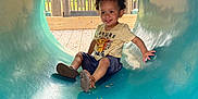 Zaelyn joined the competition — help win amazing prizes! toddler, child, playground, slide, tunnel, smiling, outdoor, park, daylight, curly_hair, casual_clothing, shorts, tshirt, shoes, wood, greenery, happy, fun, playing, sitting