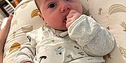 Elijah joined the competition — help win amazing prizes! baby, infant, blanket, clothing, face, hand, pillow, indoor, person, child, furniture, home, pattern, sleeve, cozy, cute, curious, lying_down, animal_print, nursery