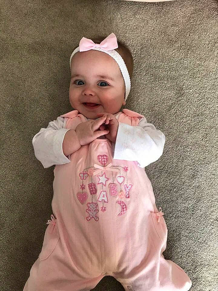 Maisie is registered to the contest to win money with this photo: baby, baby_products, baby_toddler_clothing, cheek, child, fashion_accessory, happy, headgear, person, pink, product, skin, sleeve, smile, toddler