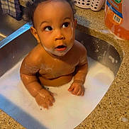 Torion is registered to the contest to win money with this photo: baby, bath, child, cleaning, container, curious, curly_hair, domestic, expression, face, foam, hands, household, infant, kitchen_counter, liquid, sink, skin, soap_bubbles, water