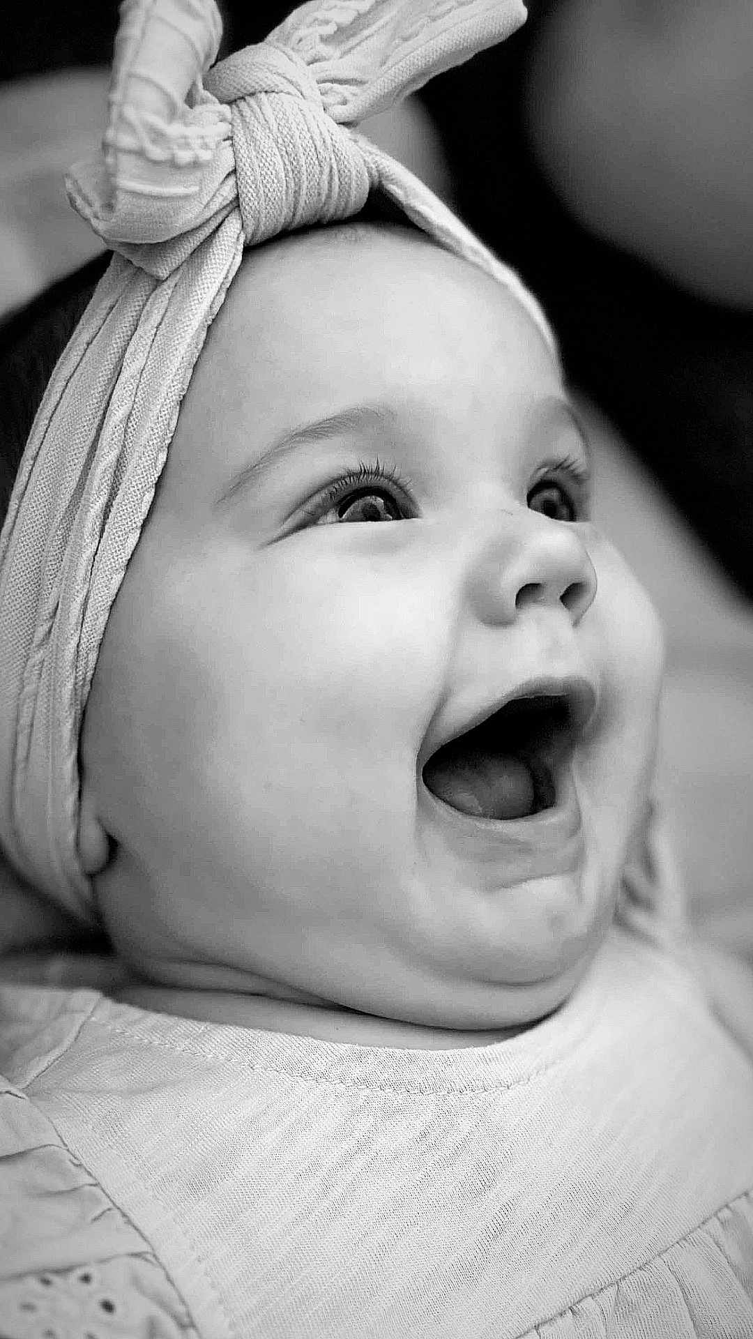 Julia a rejoint le concours — aidez-le/la à gagner de superbes lots ! baby, child, smiling, headband, bow, close_up, black_and_white, portrait, happy, infant, face, cute, eyes, clothing, soft_skin, expression, headwear, young, person, studio