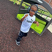 Kemon joined the competition — help win amazing prizes! bench, black_pants, boy, brick_wall, casual, child, fence, glasses, grass, green_cushion, headphones, mulch, music, outdoor, picnic_table, playground, puma, smiling, sneakers, white_shirt