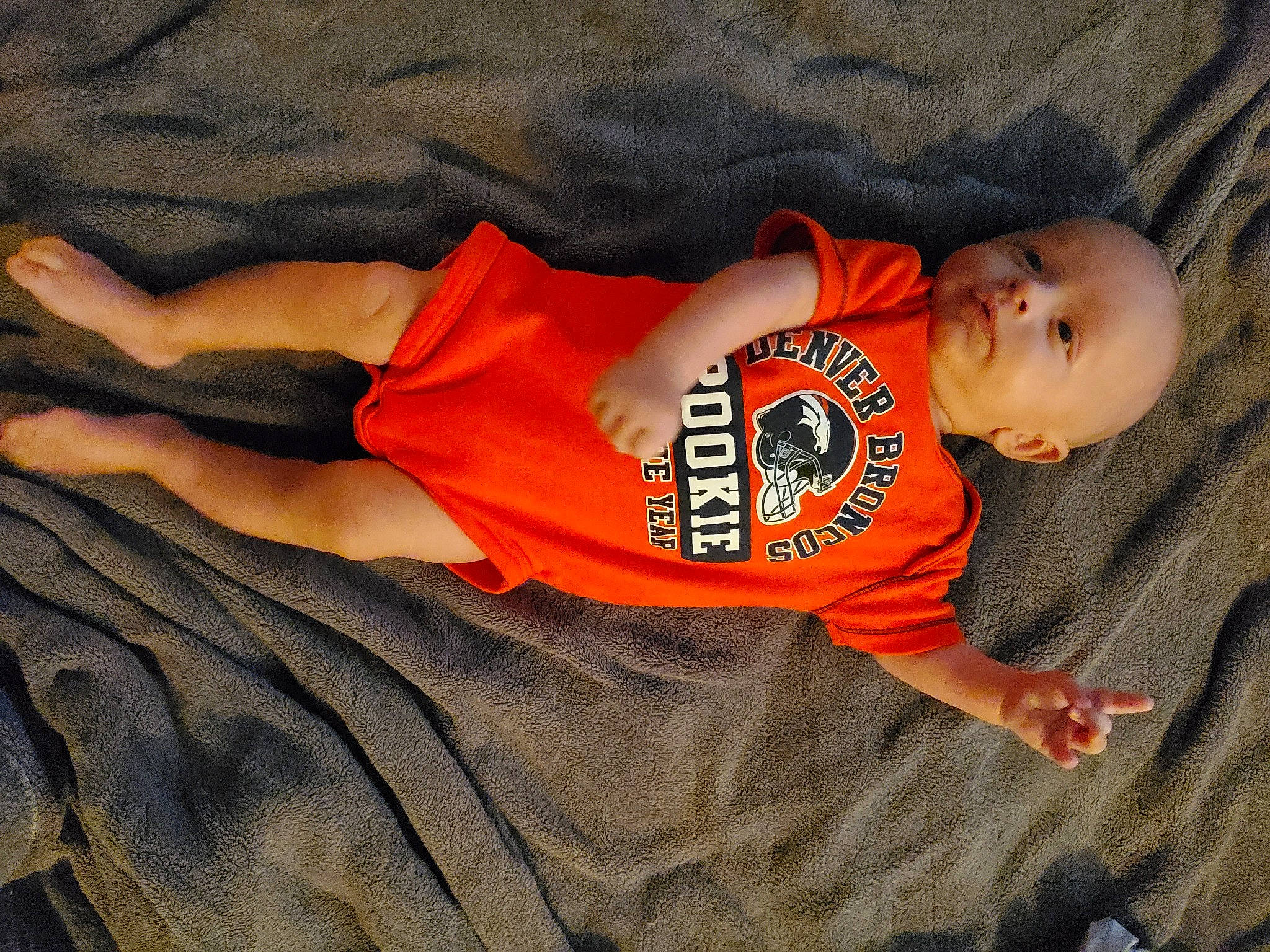 Lucas is registered to the contest to win money with this photo: abdomen, baby, baby_toddler_clothing, comfort, elbow, fun, happy, human_leg, knee, linens, orange, pattern, person, sleeve, smile, t_shirt, textile, thigh, toddler, trunk
