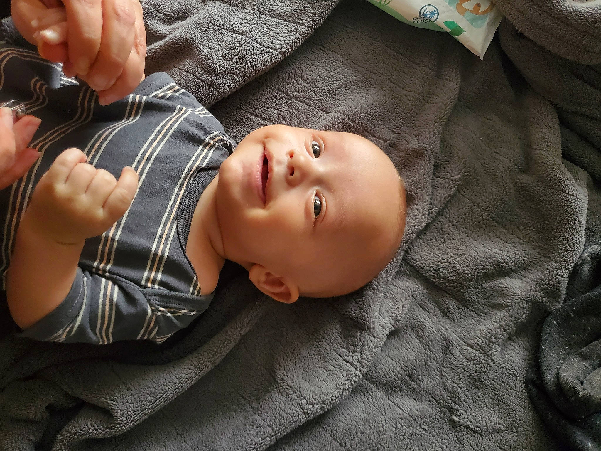 Lucas is registered to the contest to win money with this photo: baby, baby_toddler_clothing, cheek, child, comfort, flash_photography, grass, hand, happy, human_body, mouth, pattern, person, plaid, sitting, skin, smile, tartan, toddler, tree