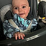 Forest is registered to the contest to win money with this photo: baby, child, high_chair, smiling, face, hand, clothing, seatbelt, indoor, person, cute, infant, happy, young, portrait, looking_at_camera, colorful, bib, baby_seat, exploring