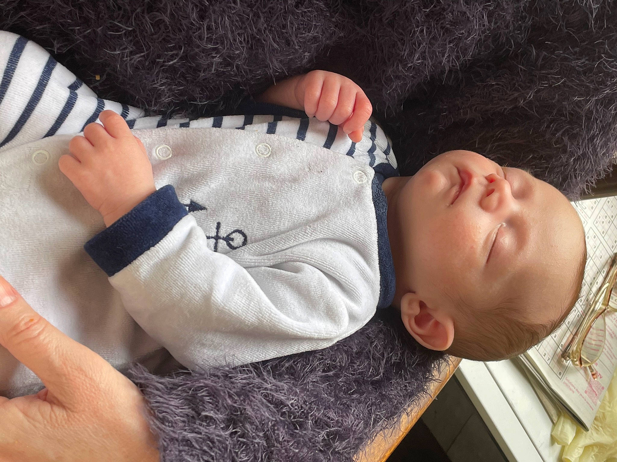 Lestat participe au concours pour gagner de l'argent avec cette photo : arm, baby, baby_sleeping, baby_toddler_clothing, cheek, child, comfort, finger, gesture, hand, human_body, nose, outerwear, person, skin, sleeve, textile, thumb, toddler, wood