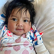 Zoemy is registered to the contest to win money with this photo: baby, child, infant, face, hair, eyes, clothing, heart_pattern, jacket, pillow, bed, cute, portrait, smile, indoors, soft_lighting, warm, cozy, skin, person