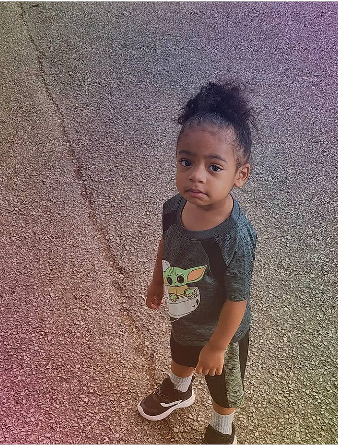 Givoni is registered to the contest to win money with this photo: asphalt, baby_toddler_clothing, child, chin, eye, grass, hair, happy, head, human_leg, leisure, people_in_nature, person, road_surface, sitting, soil, t_shirt, tints_and_shades, toddler, tree