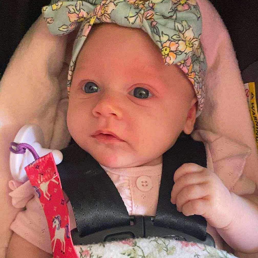 Brinlee joined the competition — help win amazing prizes! baby, blanket, car_seat, child, closeup, clothing, colorful, cute, face, floral, hand, headband, indoors, infant, newborn, pacifier, person, portrait, safety_harness, soft