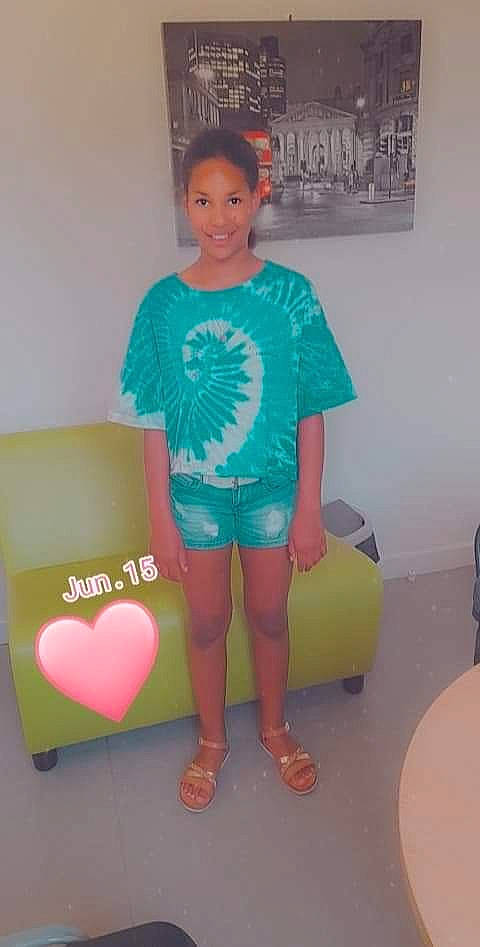 Shaina a rejoint le concours — aidez-le/la à gagner de superbes lots ! baby_toddler_clothing, child, electric_blue, flooring, fun, hairstyle, happy, human_leg, joy, knee, leg, logo, magenta, person, room, sandal, shorts, sleeve, smile, t_shirt