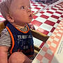 Hunter joined the competition — help win amazing prizes! baby, child, bib, high_chair, straw, diner, checkered_floor, table, red, white, striped_clothing, face, mouth, arm, leg, seat, indoor, person, drinking, curious