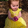 child, curious, cute, earth, forest_background, hair_tied_up, happy, holding_object, nature, outdoor, person, playful, portrait, purple_object, rosy_cheeks, sitting, sunlight, toddler, yellow_dress, young