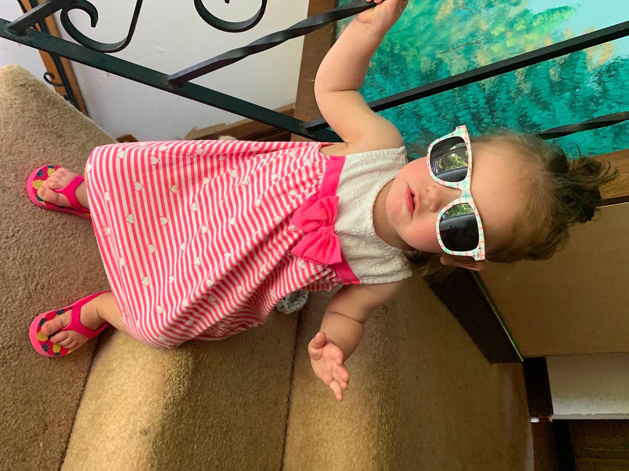 Ayana is registered to the contest to win money with this photo: baby, baby_toddler_clothing, cool, eyewear, fence, flip_flops, foot, goggles, mouth, nose, person, pink, sandal, summer, sunglasses, teal, toddler, toe, vacation, vision_care