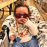 baby, child, sunglasses, stroller, blanket, bib, clothing, indoor, store, aisle, shopping, cute, hand, face, reflection, jeans, person, casual, curly_hair, seated