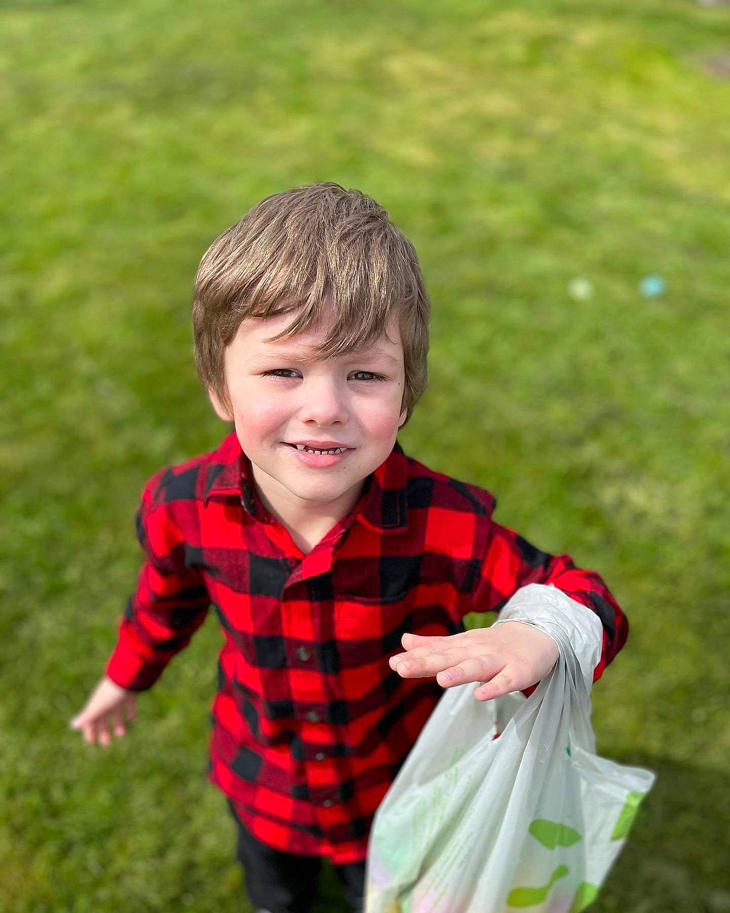Alaric is registered to the contest to win money with this photo: collar, formal_wear, fun, gesture, grass, hair, happy, joy, lawn, leisure, pattern, people_in_nature, person, plaid, plant, shirt, sitting, sleeve, smile, tartan