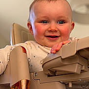 Ruben Correia a rejoint le concours — aidez-le/la à gagner de superbes lots ! baby, child, high_chair, smiling, happy, rosy_cheeks, blue_eyes, hand, face, indoor, furniture, clothing, person, portrait, cute, toddler, infant, closeup, skin, expression