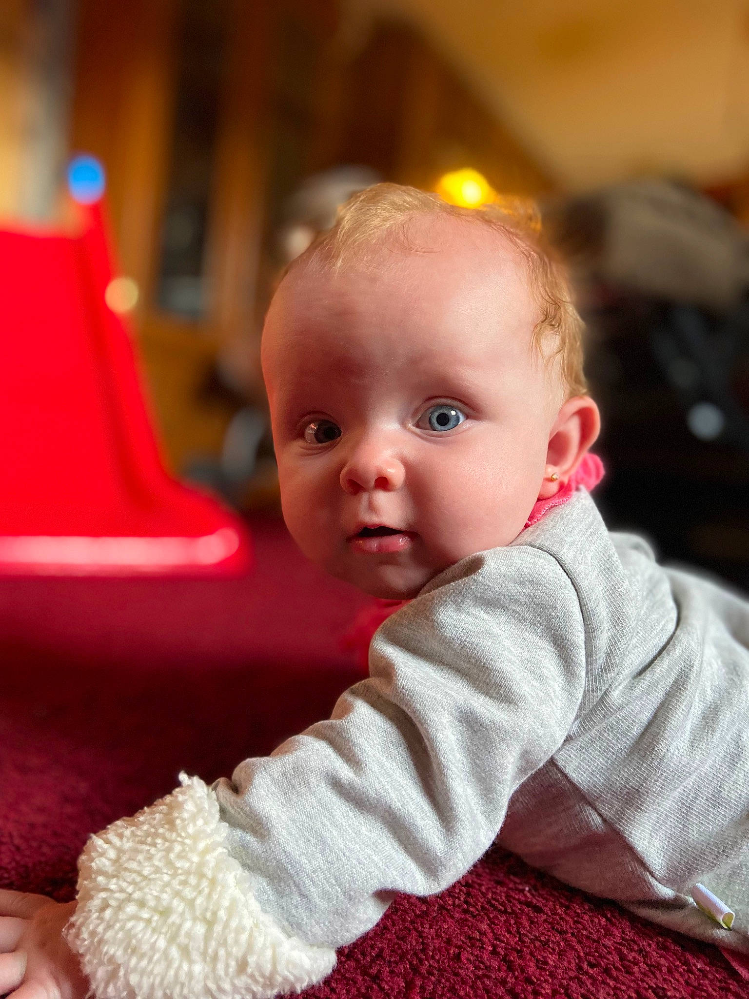 Isabelle is registered to the contest to win money with this photo: baby, baby_toddler_clothing, cheek, child, comfort, event, eye, facial_expression, flooring, fun, hair, hairstyle, head, iris, person, sitting, skin, sleeve, smile, toddler