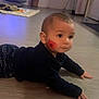 baby, black_clothing, cheek_mark, child, crawling, cute, expression, face_paint, floor, flooring, hands, head, indoor, infant, patterned_pants, person, skin, wide_eyes, wooden_floor, young_child