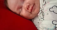 Ellieana joined the competition — help win amazing prizes! baby, sleeping, red_pillow, onesie, cloud_pattern, hand, face, infant, cozy, smile, indoor, bedroom, door, blanket, cute, peaceful, resting, soft, child, portrait