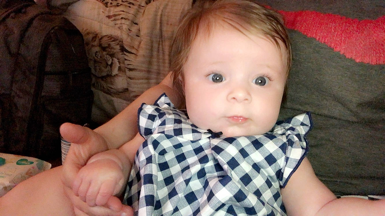 Bristol is registered to the contest to win money with this photo: baby, cheek, child, chin, design, ear, eye, face, finger, hand, head, iris, lip, mouth, nose, pattern, person, plaid, skin, thumb