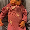 baby, infant, child, portrait, lying_down, pink_onesie, onesie, gray_bedding, blanket, bed, indoors, wide_eyes, tousled_hair, looking_at_camera, hands, zipper, soft_lighting, cozy, close_up, expression