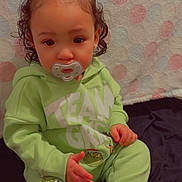 Juniper joined the competition — help win amazing prizes! toddler, child, pacifier, bow, curly_hair, green_clothing, sitting, polka_dot_background, cartoon_print, grinch, long_sleeve, pants, indoor, cute, baby, face, hand, foot, portrait, clothing