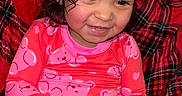 Juniper is registered to the contest to win money with this photo: baby_bottle, casual, child, cozy, curly_hair, cute, diaper, happy, indoors, infant, pacifier, person, pink_clothing, plaid_blanket, portrait, rosy_cheeks, sitting, smiling, toddler, young_child
