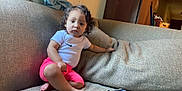 Juniper joined the competition — help win amazing prizes! barefoot, casual_clothing, child, comfort, couch, curly_hair, expression, furniture, home, indoor, living_room, person, pink_shorts, portrait, relaxed, seated, sofa, toddler, white_tshirt, young_child
