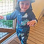 Aryson participe au concours pour gagner de l'argent avec cette photo : child, toddler, smiling, hat, cap, shark_pattern, outdoor, wooden_floor, net_fence, blue_clothing, cartoon_slippers, playful, cute, happy, daylight, person, footwear, standing, casual, summer