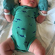 Joseph is registered to the contest to win money with this photo: newborn, baby, infant, sleeping, onesie, green_clothing, mittens, socks, blanket, bed, resting, peaceful, cute, soft, cozy, dinosaur_pattern, infant_clothing, human, skin, laying_down