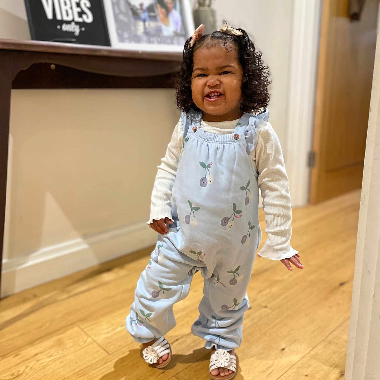 Chloe is registered to the contest to win money with this photo: baby, babylaughing, blackhair, child, clothing, curlyhair, face, female, footwear, girl, hair, happy, head, pajamas, pants, person, shoe, sitting, sleeve, standing