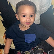 Ky Marshaun is registered to the contest to win money with this photo: toddler, child, smiling, indoor, blanket, clothing, pants, shirt, face, person, cute, sitting, young_child, curly_hair, black_hair, comfort, home, portrait, casual, playful