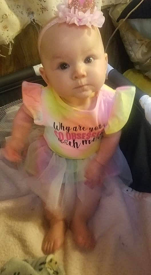 Pepper is registered to the contest to win money with this photo: baby, baby_carriage, baby_products, baby_safety, baby_toddler_clothing, cheek, drinkware, eye, eyebrow, eyelash, face, happy, human_body, linens, person, pink, skin, sleeve, t_shirt, thumb