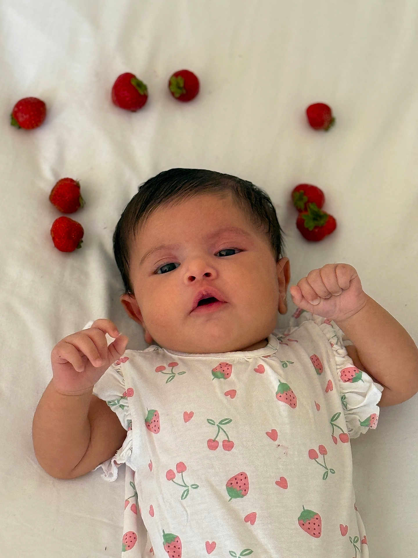 Layane participe au concours pour gagner de l'argent avec cette photo : baby, infant, strawberries, fruit, white_background, cute, patterned_clothing, child, lying_down, soft_texture, pink_hearts, cherry_pattern, fresh, healthy, small_hands, sleepy_eyes, casual, adorable, natural_light, portrait