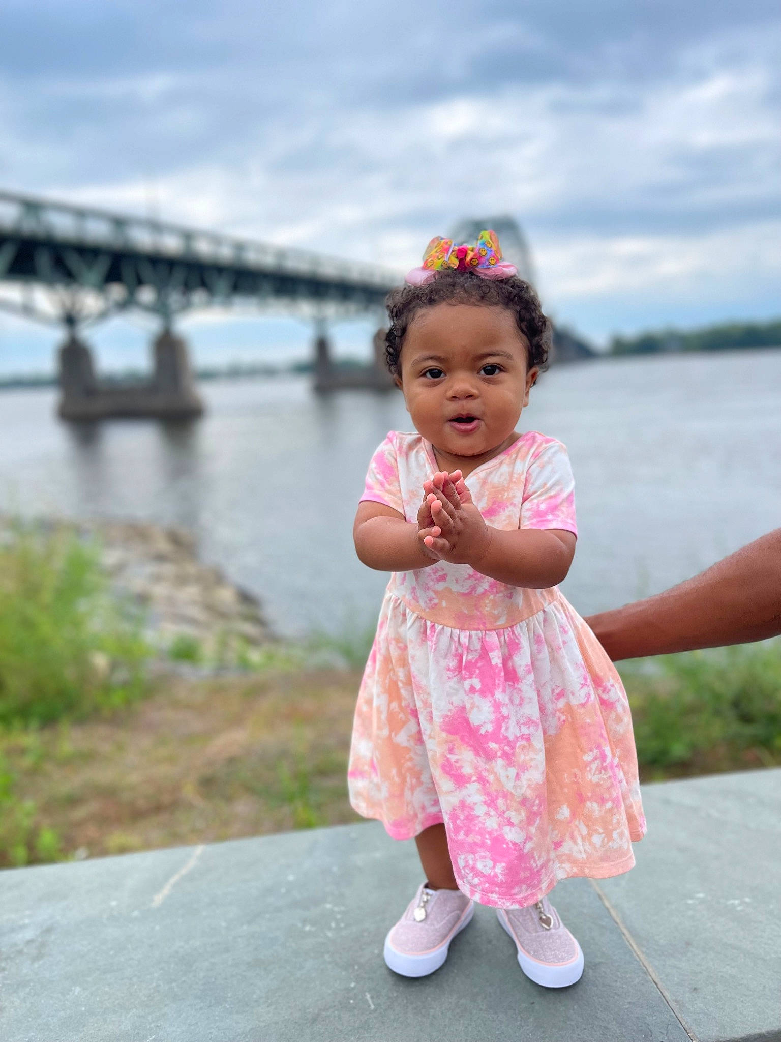 Luna Paredes is registered to the contest to win money with this photo: baby_toddler_clothing, child, cloud, dress, fun, gesture, grass, hand, happy, lake, leisure, people_in_nature, person, plant, recreation, skin, sky, summer, toddler, travel