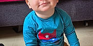 Kenzho participe au concours pour gagner de l'argent avec cette photo : toddler, child, smiling, sitting, floor, blue_shirt, yellow_pants, shoes, sock, face, indoor, couch, blanket, home, cute, happy, person, baby, casual, portrait