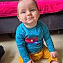 toddler, child, smiling, sitting, floor, blue_shirt, yellow_pants, shoes, sock, face, indoor, couch, blanket, home, cute, happy, person, baby, casual, portrait