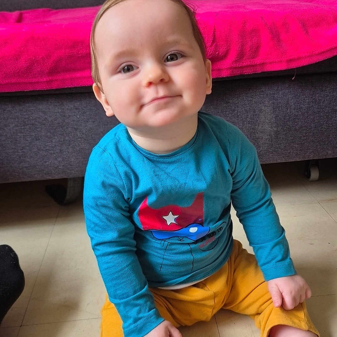 Kenzho participe au concours pour gagner de l'argent avec cette photo : baby, blanket, blue_shirt, casual, child, couch, cute, face, floor, happy, home, indoor, person, portrait, shoes, sitting, smiling, sock, toddler, yellow_pants