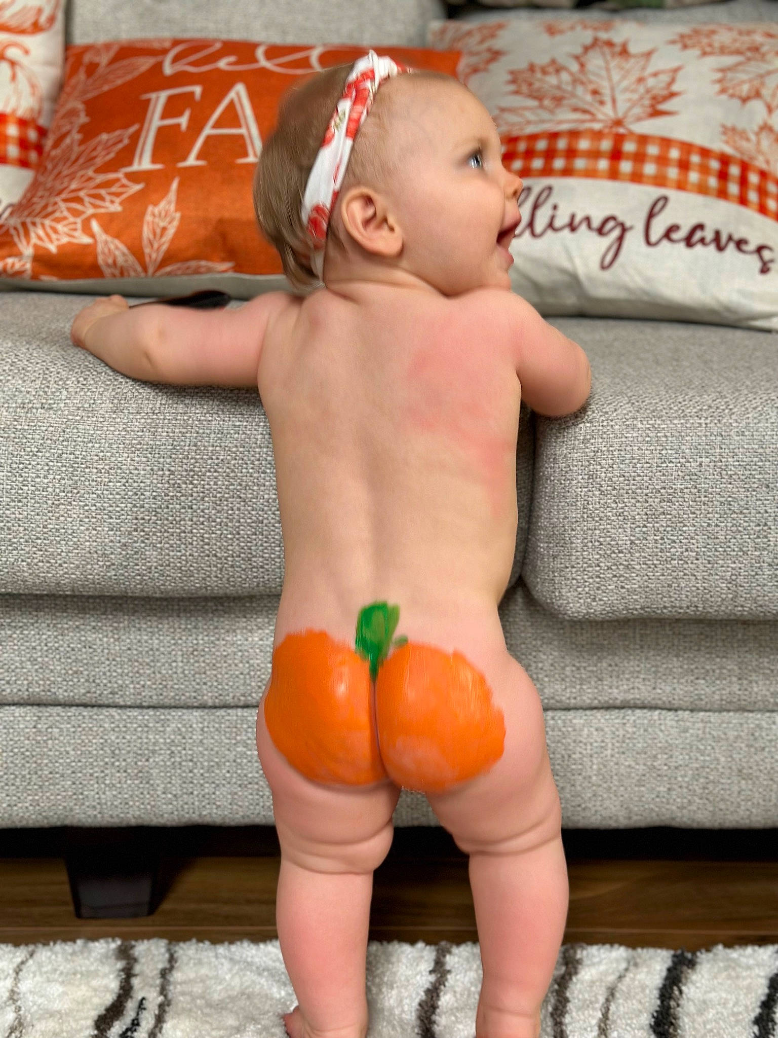 Sally is registered to the contest to win money with this photo: abdomen, arm, baby, barechested, barefoot, bathing, chest, face, hand, head, headgear, human_body, human_leg, neck, orange, person, skin, stomach, thigh, toddler