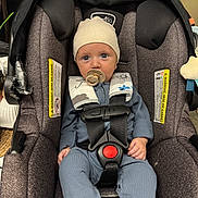 Brewer joined the competition — help win amazing prizes! baby, car_seat, pacifier, hat, blue_outfit, infant, child, seatbelt, safety_harness, indoor, person, cute, young_child, child_baby, infant_clothing, headwear, small_child, seated, face, looking