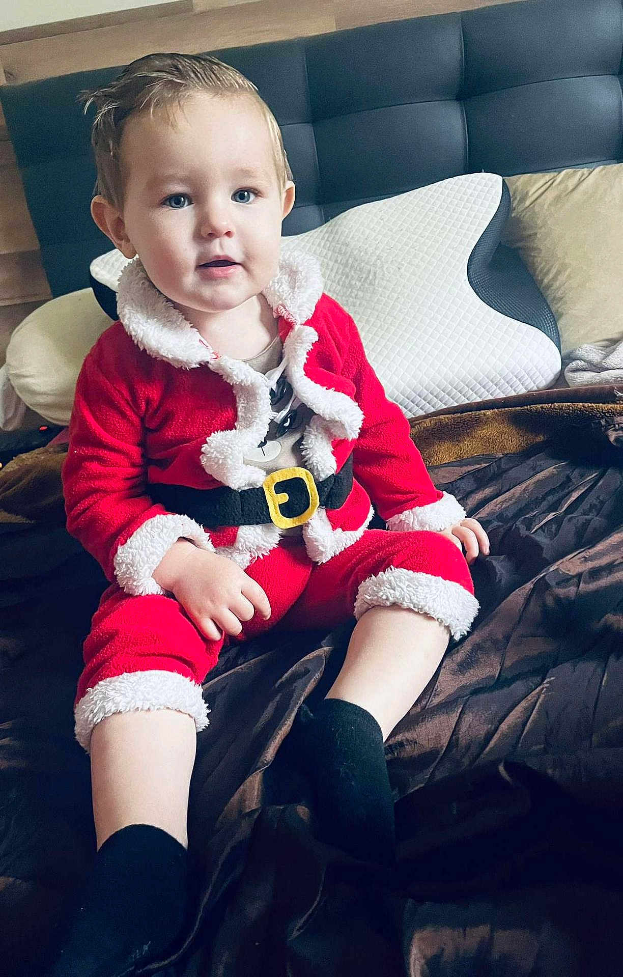 Tayler a rejoint le concours — aidez-le/la à gagner de superbes lots ! toddler, child, santa_outfit, red_clothing, black_socks, bed, pillow, blanket, indoor, portrait, cute, holiday, christmas, smile, face, person, young_child, sitting, cozy, head