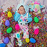 baby, bunny_costume, celebration, child, colorful, cute, easter_eggs, festive, holiday, holiday_theme, infant, lying_down, pastel_colors, pink_background, plush_toy, portrait, shredded_paper, sleepy, soft_fabric, toy