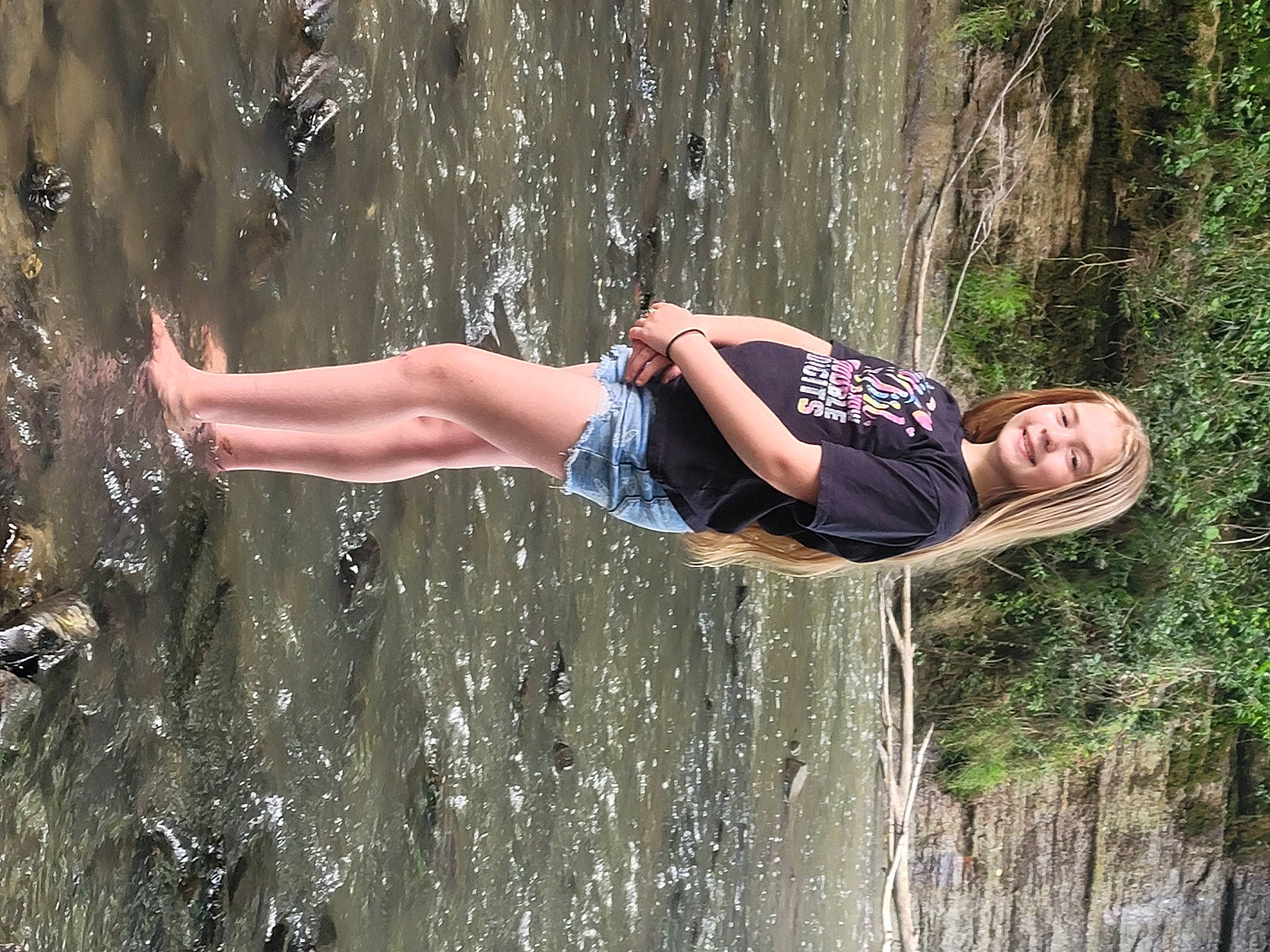 Alivia is registered to the contest to win money with this photo: adventure, barefoot, flash_photography, forest, fun, grass, happy, human_leg, joy, leisure, nature, people_in_nature, person, recreation, rock, shorts, sitting, thigh, tree, water